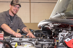 Heavy Duty Mechanic Student works on a large truck engine