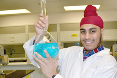 Chemistry student holding beaker of blue fluid